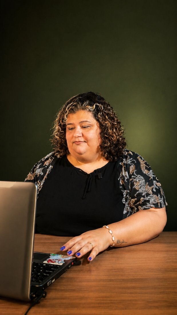 Grazielle Setti no consultório, trabalhando ao computador.