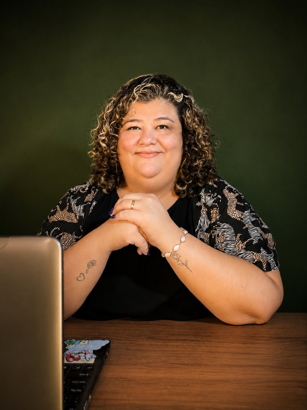 Grazielle Setti, psicóloga, sentada à mesa do consultório, sorrindo para a câmera.